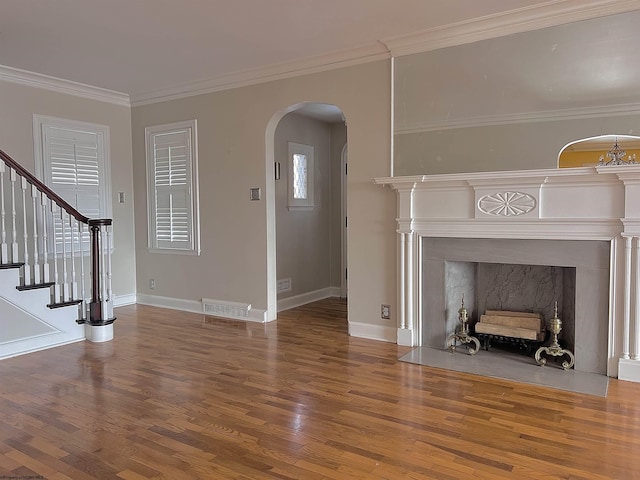 unfurnished living room with wood-type flooring and crown molding