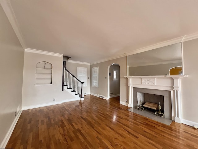 unfurnished living room featuring wood-type flooring, built in features, and crown molding