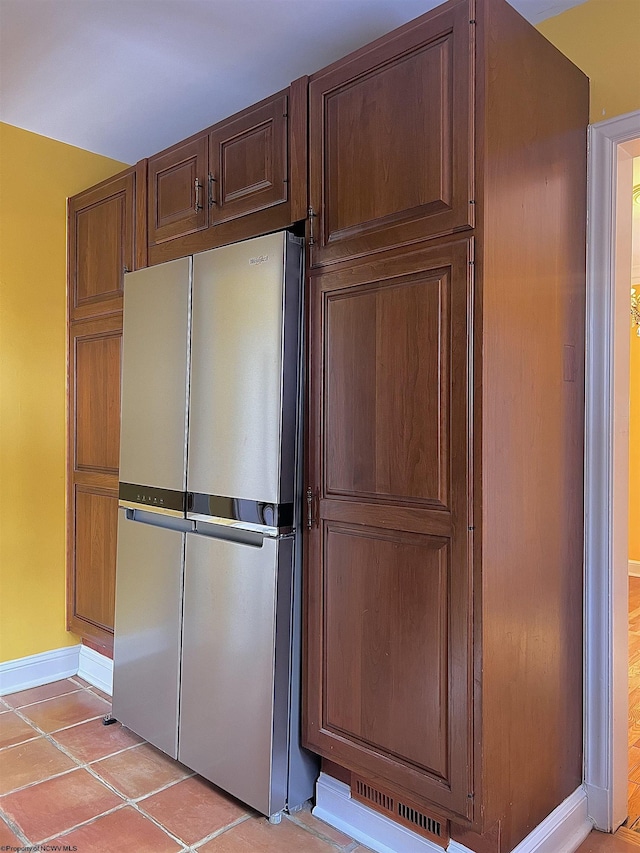 kitchen featuring light tile patterned floors and stainless steel fridge