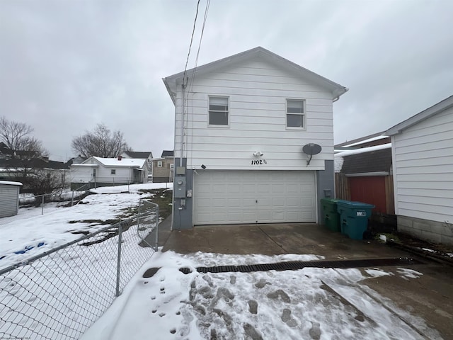 view of snow covered exterior with a garage