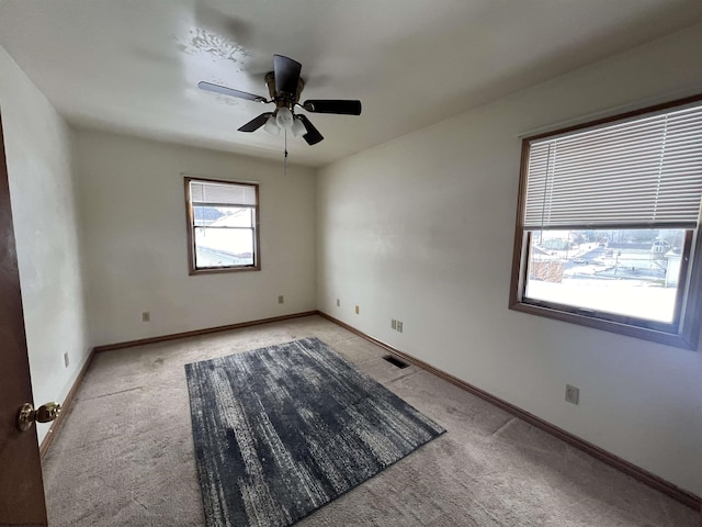 carpeted spare room with ceiling fan