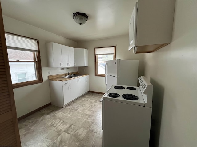 kitchen with white cabinetry, sink, and white appliances