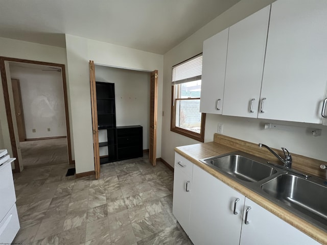 kitchen featuring white cabinetry and sink