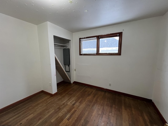 unfurnished bedroom featuring dark wood-type flooring and a closet