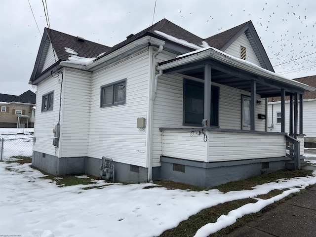 snow covered property with a porch