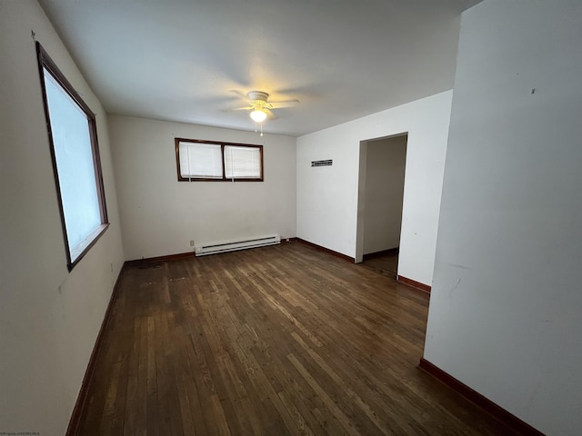 spare room with ceiling fan, a baseboard heating unit, and dark hardwood / wood-style floors