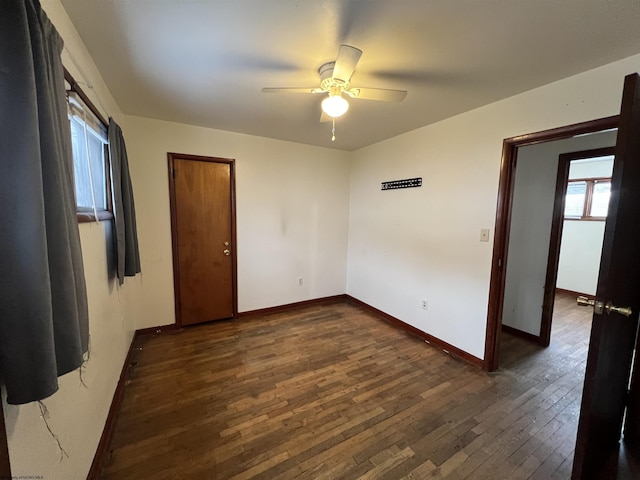 unfurnished room featuring ceiling fan, a healthy amount of sunlight, and dark hardwood / wood-style floors