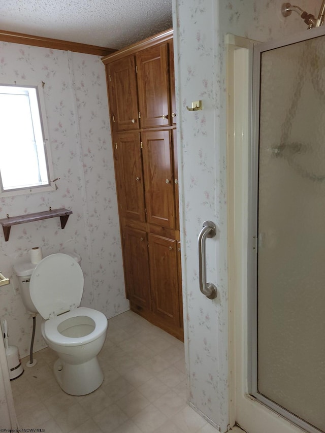 bathroom with toilet, a shower with door, crown molding, and a textured ceiling