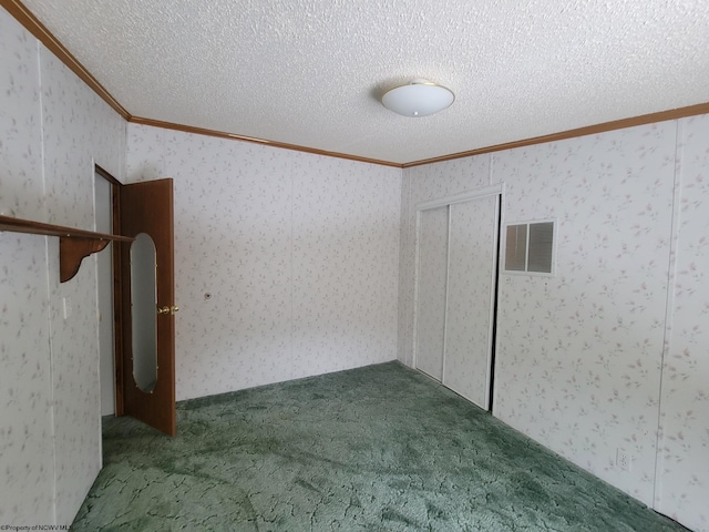 carpeted empty room with crown molding and a textured ceiling