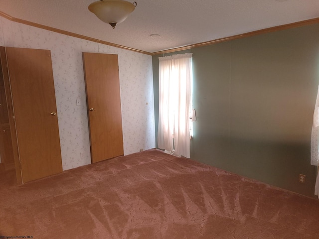 carpeted empty room featuring vaulted ceiling and crown molding