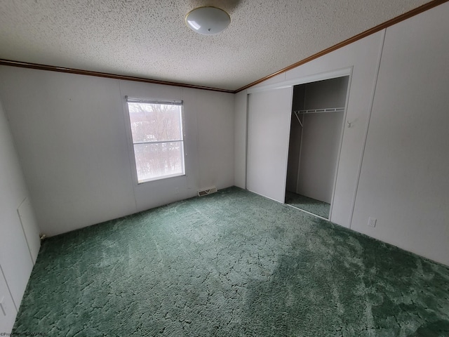 unfurnished bedroom featuring carpet floors, lofted ceiling, crown molding, a textured ceiling, and a closet