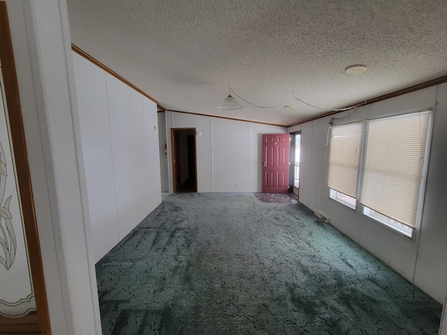 carpeted empty room featuring a textured ceiling and crown molding