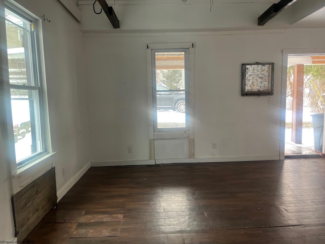 spare room with a healthy amount of sunlight and dark hardwood / wood-style flooring