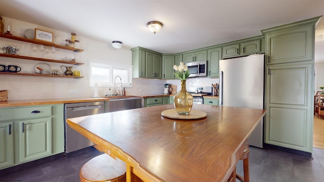 kitchen featuring decorative backsplash, sink, green cabinets, and stainless steel appliances