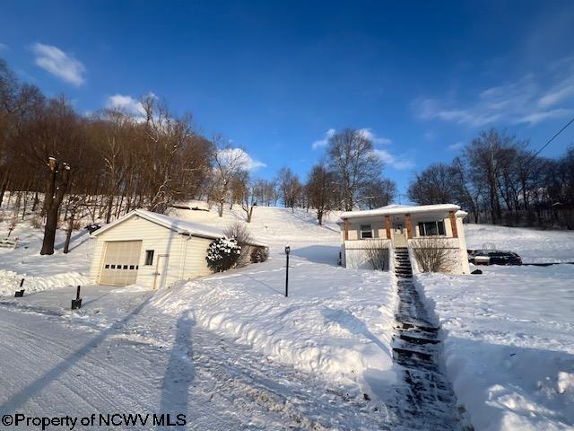 view of front of house featuring a garage, an outbuilding, and covered porch