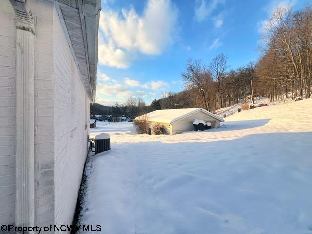 yard layered in snow featuring cooling unit