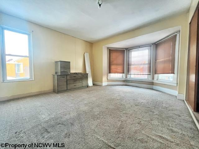 unfurnished living room featuring a healthy amount of sunlight and carpet floors