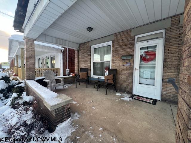 snow covered patio with a porch