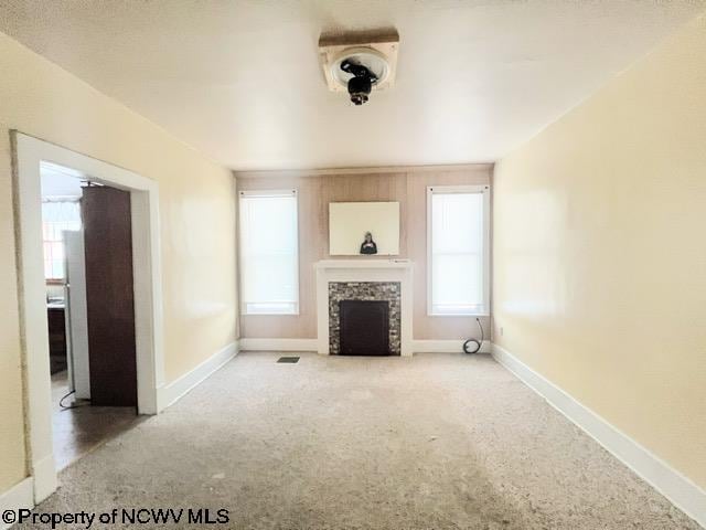 unfurnished living room with a fireplace and carpet floors