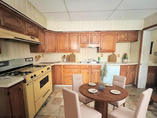 kitchen featuring a drop ceiling, sink, and white appliances