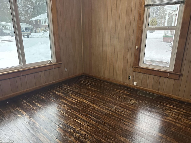 unfurnished room with a wealth of natural light and dark hardwood / wood-style floors