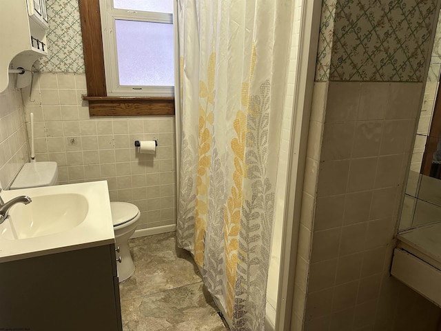 bathroom featuring toilet, vanity, tile walls, and water heater