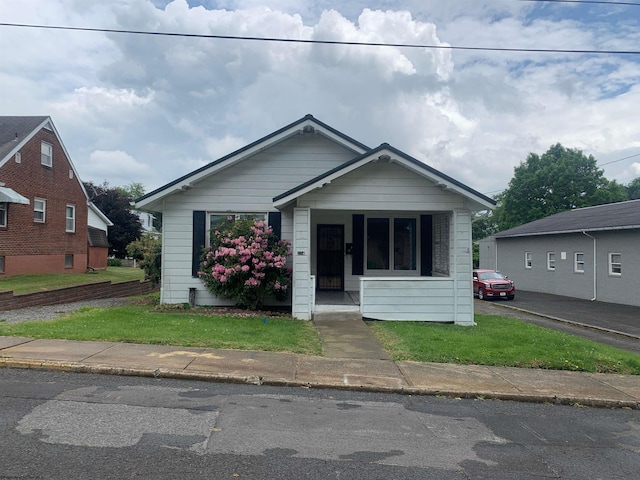 bungalow-style home featuring a front lawn