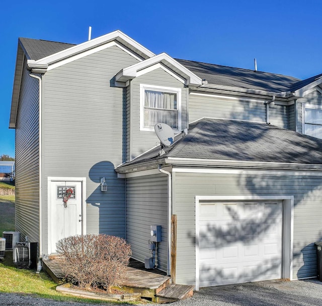 view of home's exterior with a garage and central AC unit