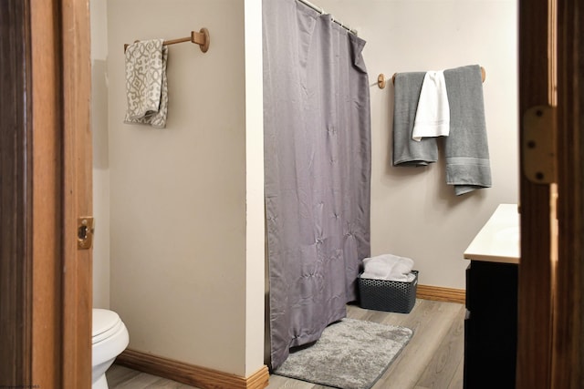 bathroom featuring vanity, wood-type flooring, toilet, and walk in shower