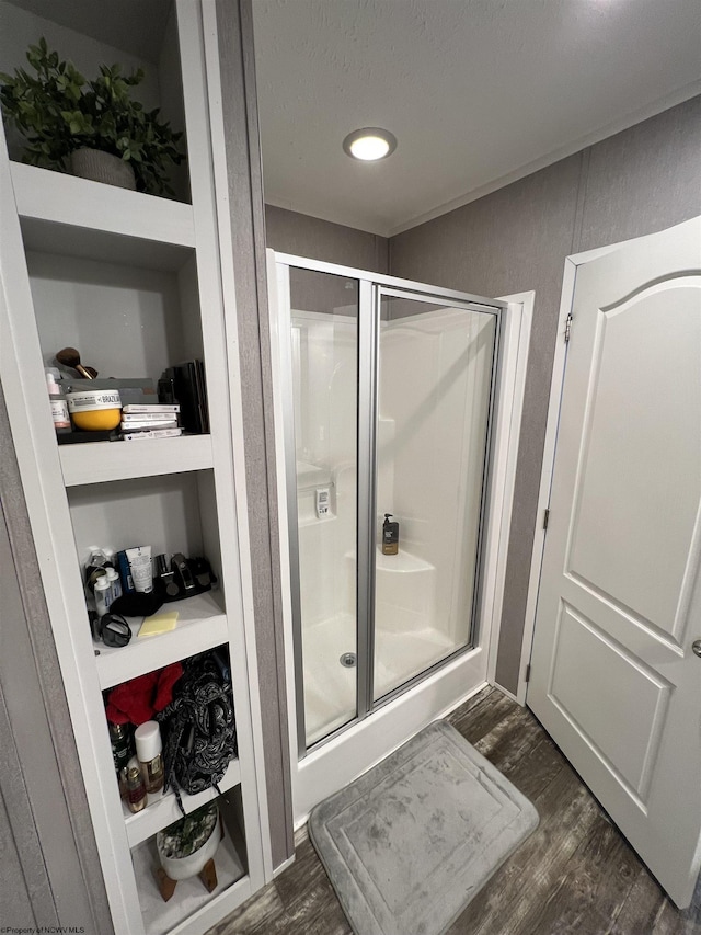 full bath with a stall shower and wood finished floors