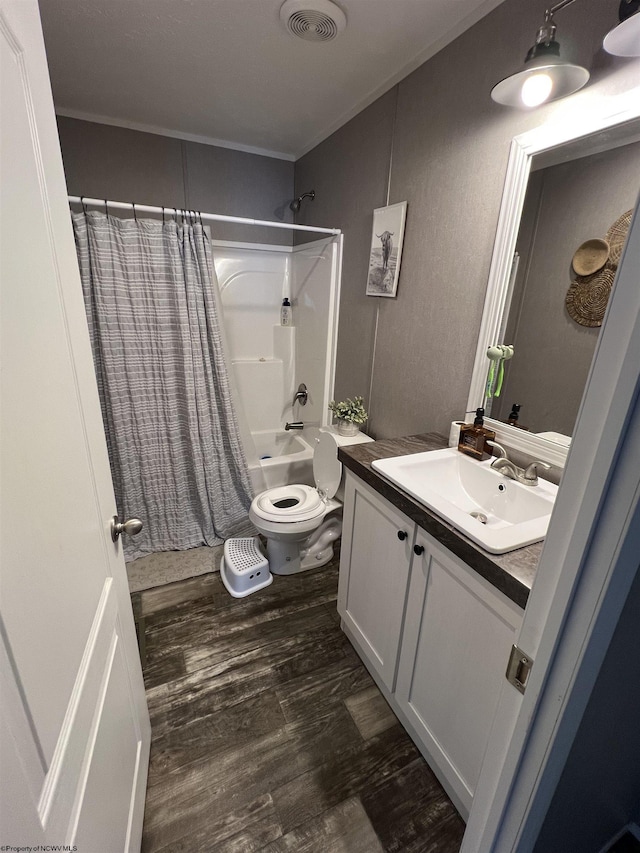 full bath featuring visible vents, toilet, shower / bath combo, vanity, and wood finished floors