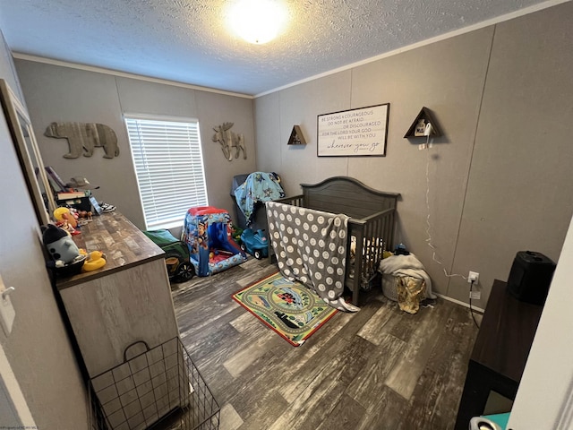 bedroom with a textured ceiling, ornamental molding, and wood finished floors