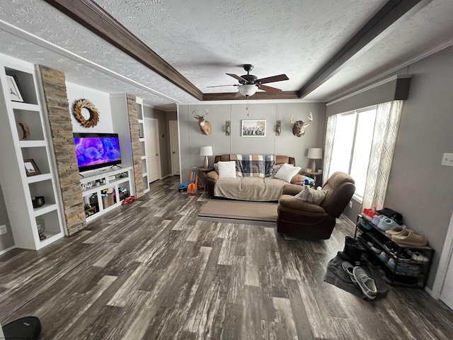 living room with a textured ceiling, built in features, a tray ceiling, dark wood finished floors, and crown molding