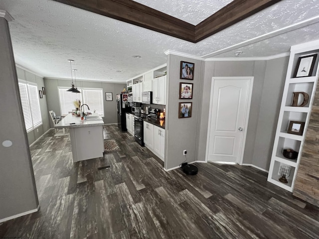 kitchen featuring a breakfast bar, a center island with sink, white cabinetry, a sink, and black appliances