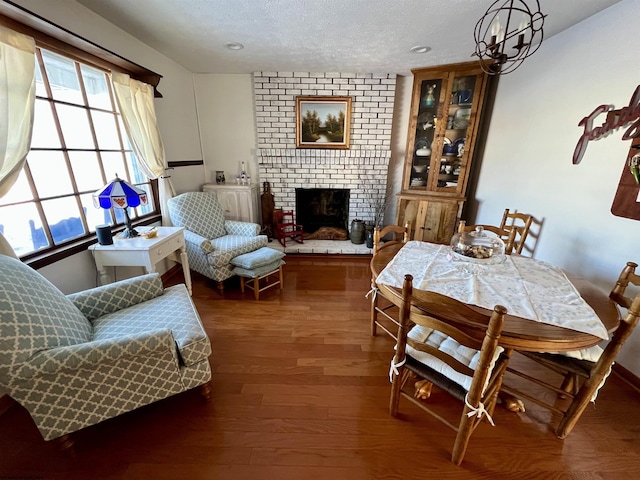 dining space featuring a wealth of natural light, a brick fireplace, dark hardwood / wood-style floors, and a textured ceiling