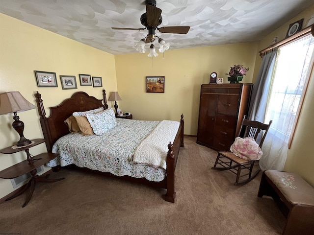 bedroom with ceiling fan, light colored carpet, and a textured ceiling