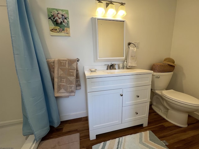 bathroom with hardwood / wood-style flooring, toilet, vanity, and a shower with shower curtain