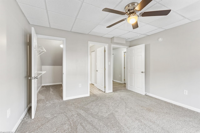 unfurnished bedroom with a paneled ceiling, ceiling fan, and light colored carpet