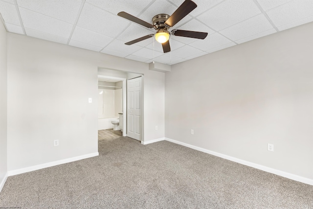 spare room featuring a drop ceiling, carpet flooring, and ceiling fan