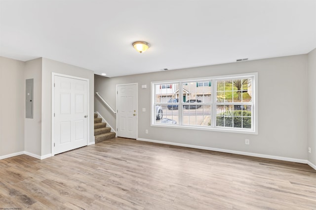 interior space featuring electric panel and light hardwood / wood-style floors