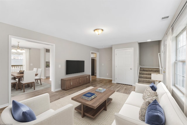 living room featuring an inviting chandelier and light wood-type flooring