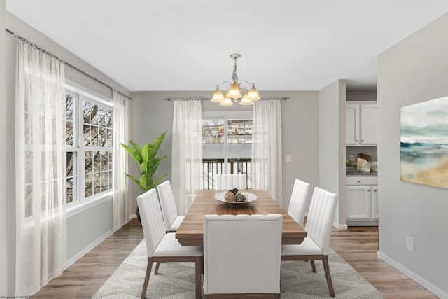 dining area featuring light hardwood / wood-style floors and a notable chandelier