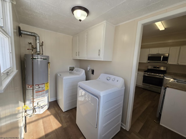 laundry area with water heater, cabinets, dark wood-type flooring, sink, and independent washer and dryer