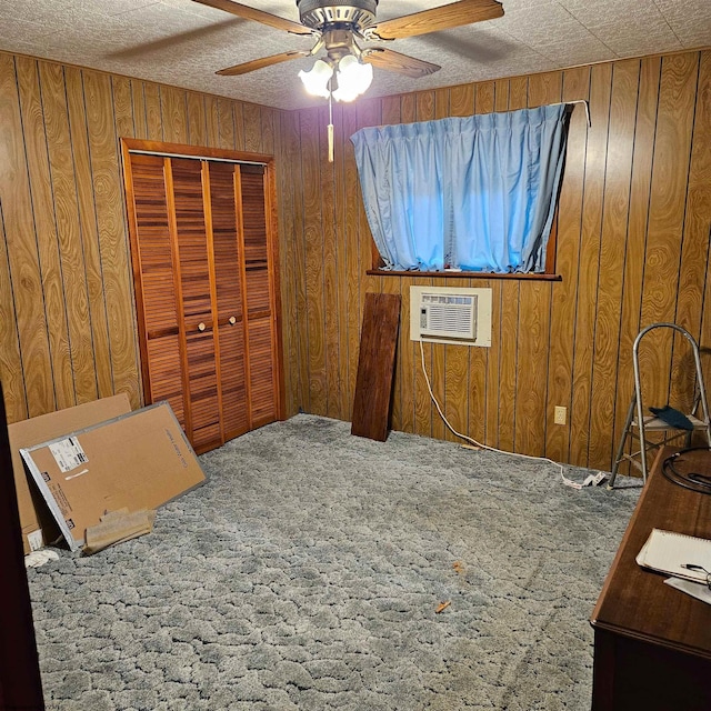 carpeted bedroom featuring ceiling fan, an AC wall unit, a closet, and wood walls