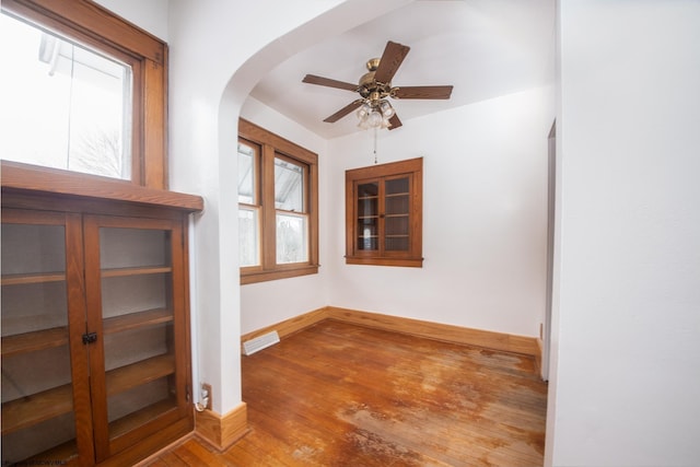 empty room with ceiling fan and hardwood / wood-style floors