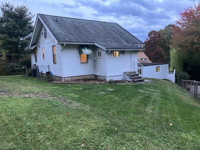 back of house with cooling unit and a lawn