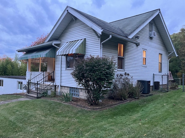 view of side of home featuring cooling unit, central air condition unit, and a lawn