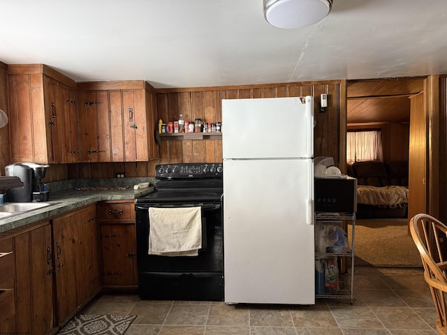 kitchen with sink, electric range, wooden walls, and white refrigerator