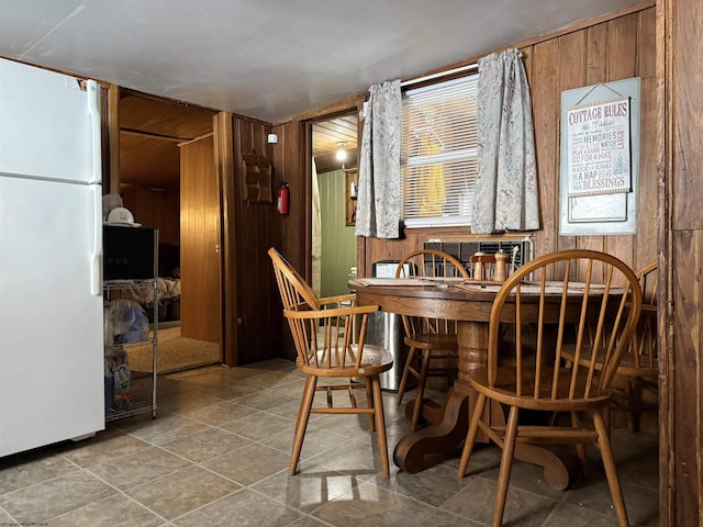 dining space featuring bar and wood walls