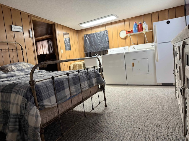 carpeted bedroom featuring washer and clothes dryer, wooden walls, a textured ceiling, and white refrigerator